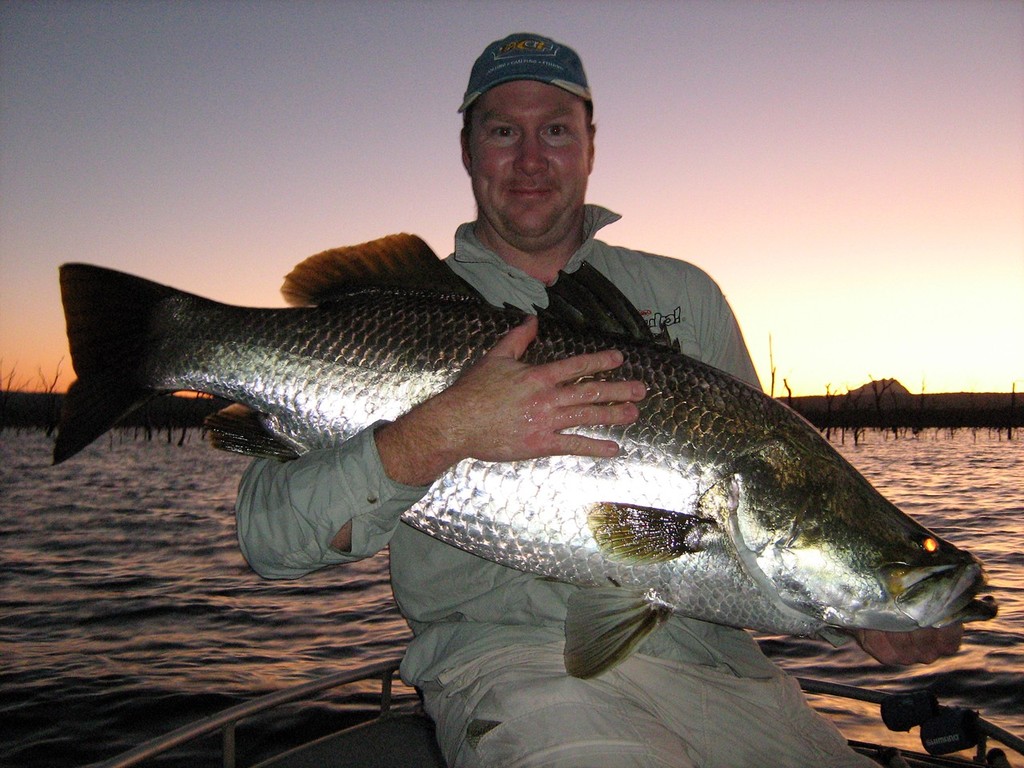 Jason Crofts with a Peter Faust metre barra.  Faust has always been a big barra dam, but it does suffer during big rain events. © Lee Brake